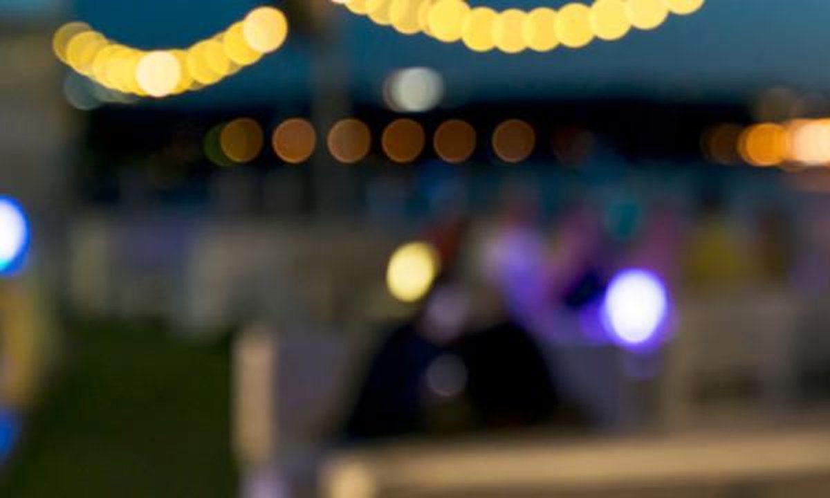 European winter tourists strolling sunny Spanish coastal promenade with luggage