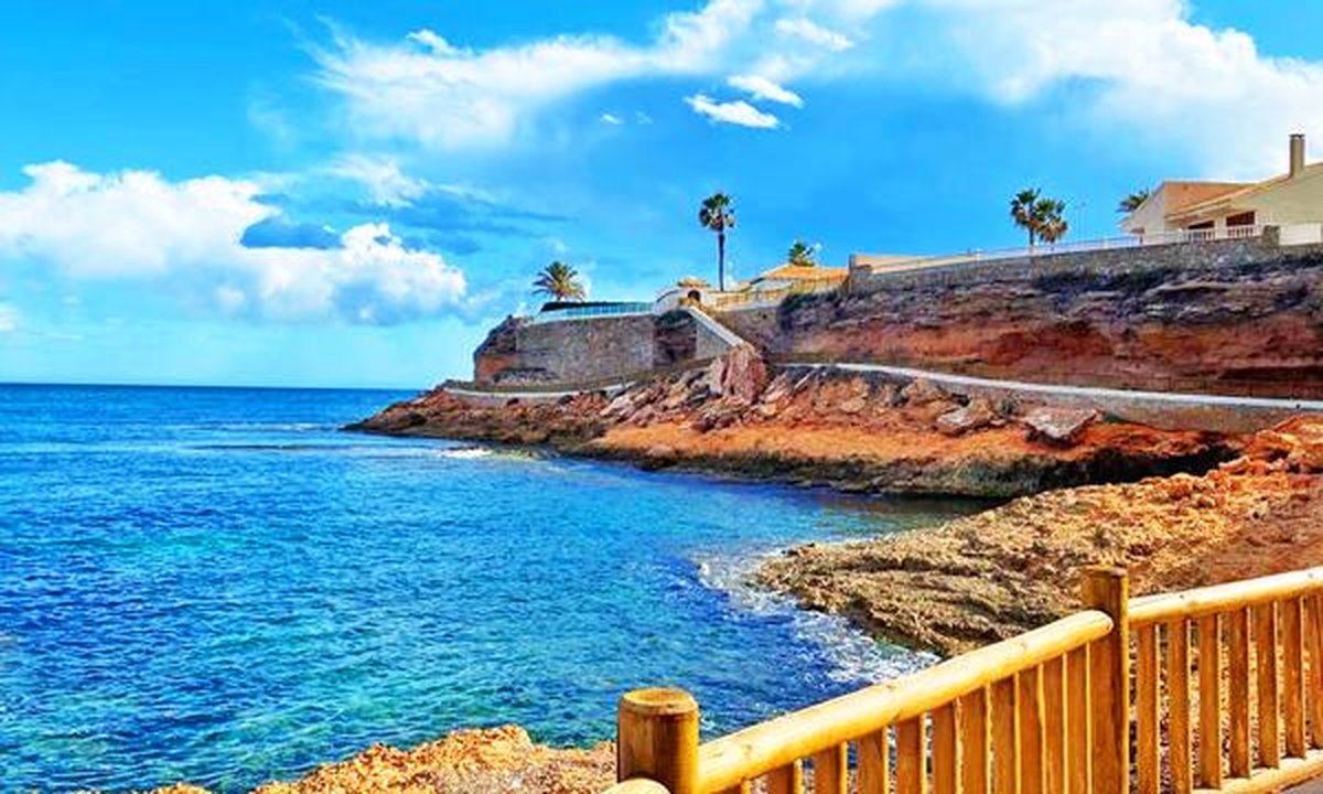 Orihuela Costa coastline with villas and real estate for sale signage