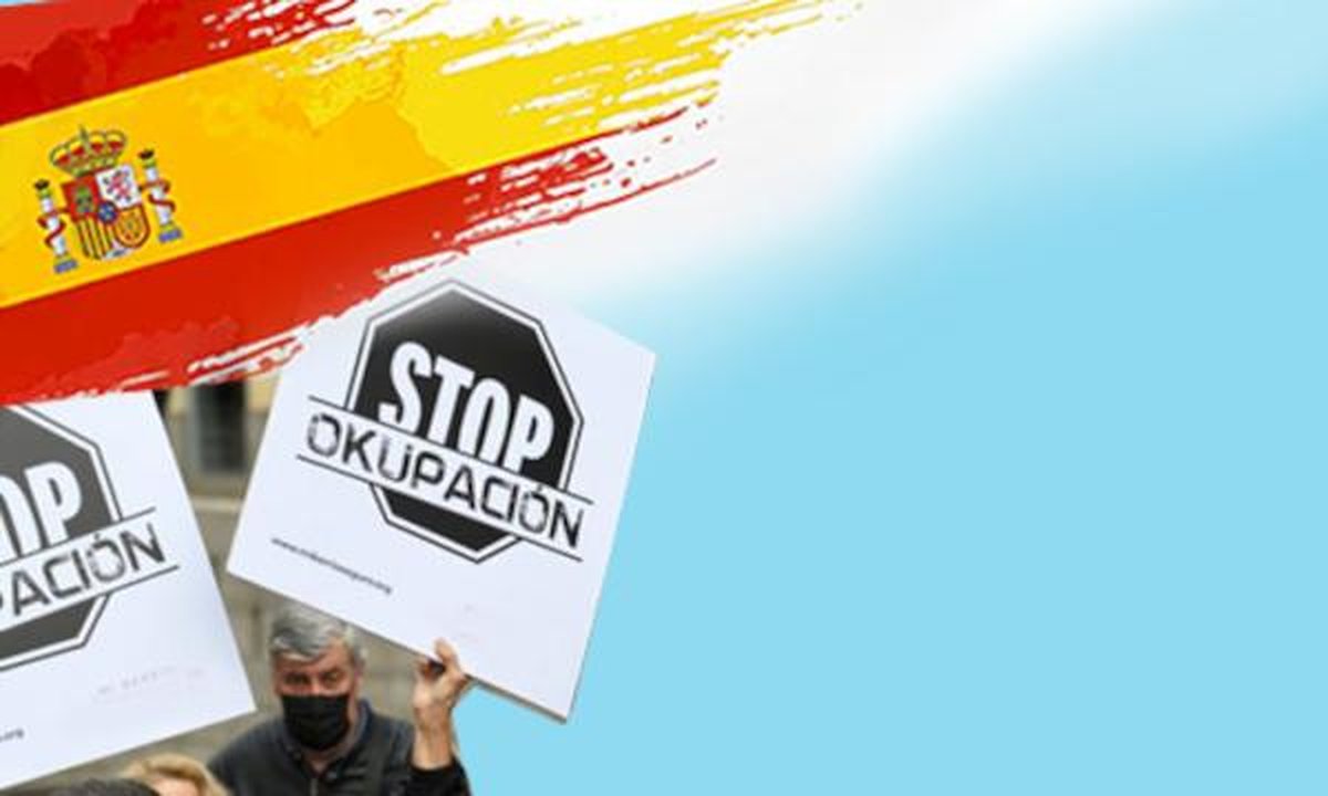 Blocked Spanish apartment door with squatters' belongings and eviction notice